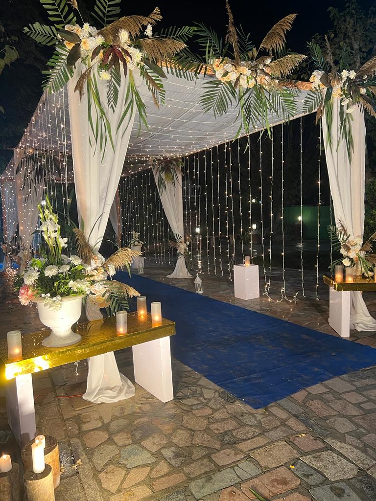 Outdoor starlight ceiling draped with thousands of warm micro-LED fairy lights and candle centerpieces