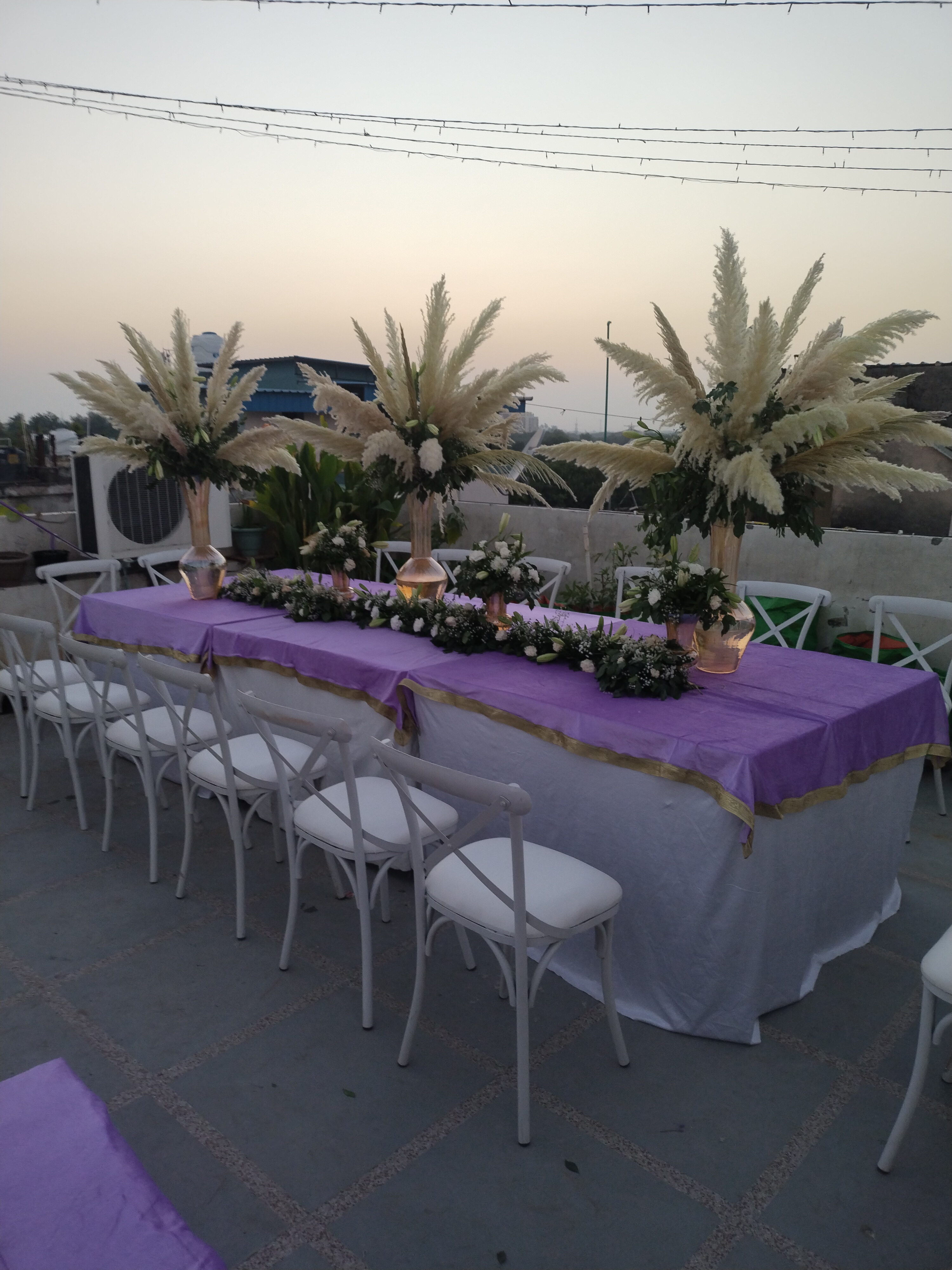Imperial rooftop royal banquet table with purple runner and pampas grass centerpieces