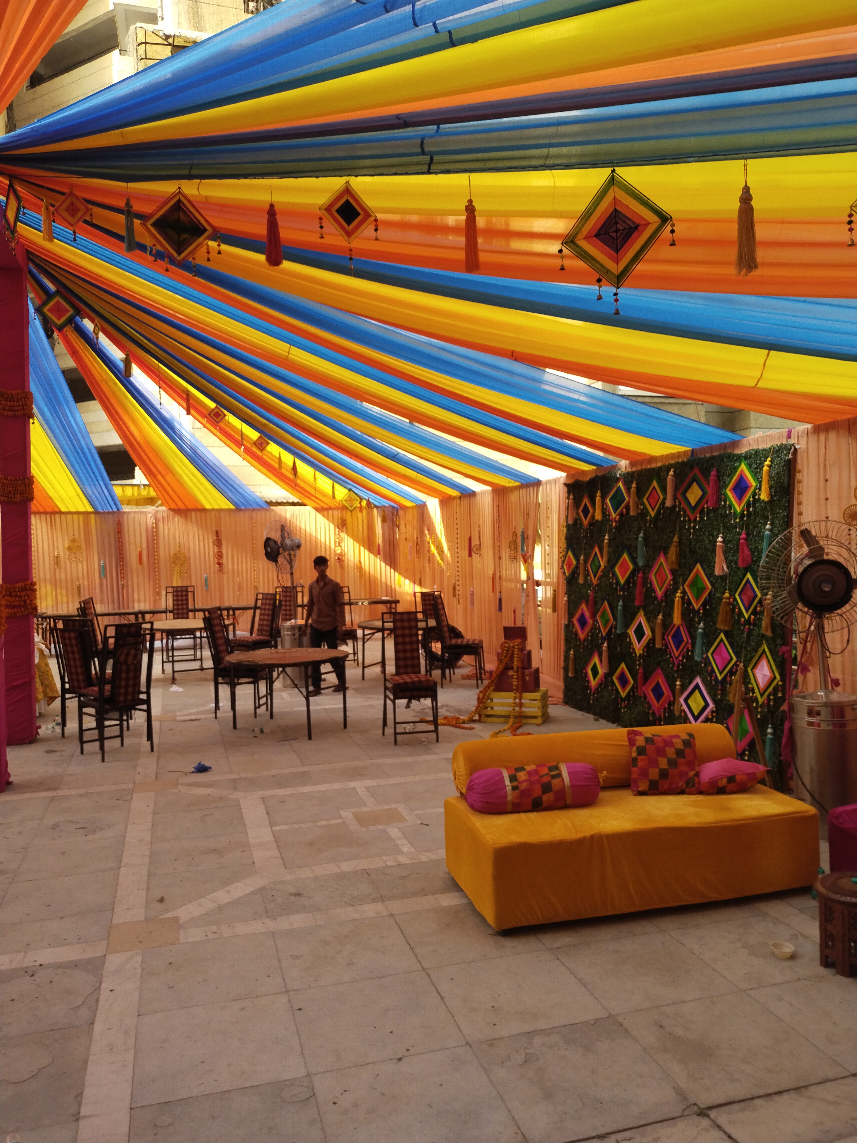 Radiant kaleidoscopic fabric canopy in sunshine yellow and turquoise with yellow diwan seating